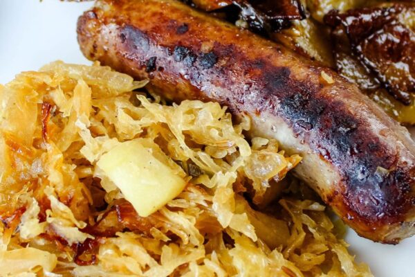 Flavorful German Sauerkraut with Bratwurst, crispy Bacon, and caramelized Onions for a hearty dish.